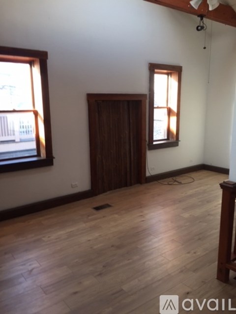 A room with wooden floors and a ceiling fan.