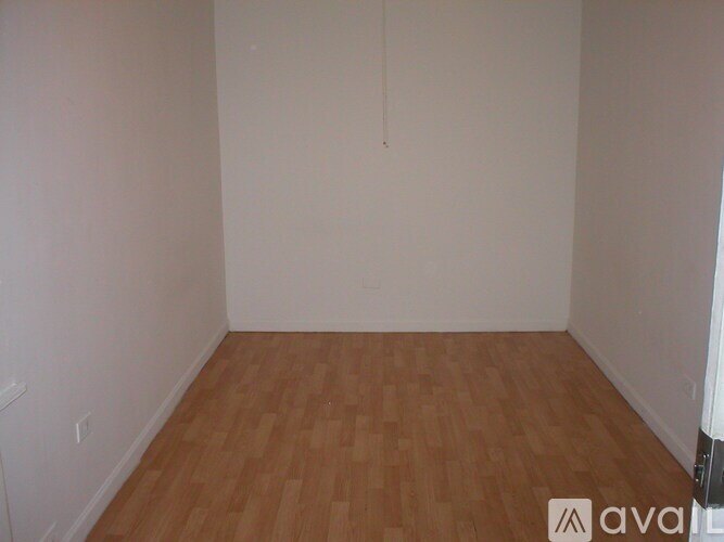 A room with wooden flooring and white walls.