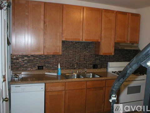 A kitchen with wooden cabinets and a brick backsplash.