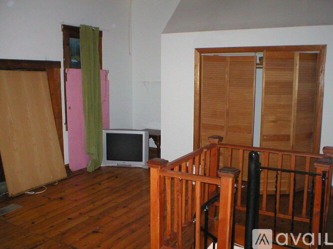 A room with a TV and wooden shutters.