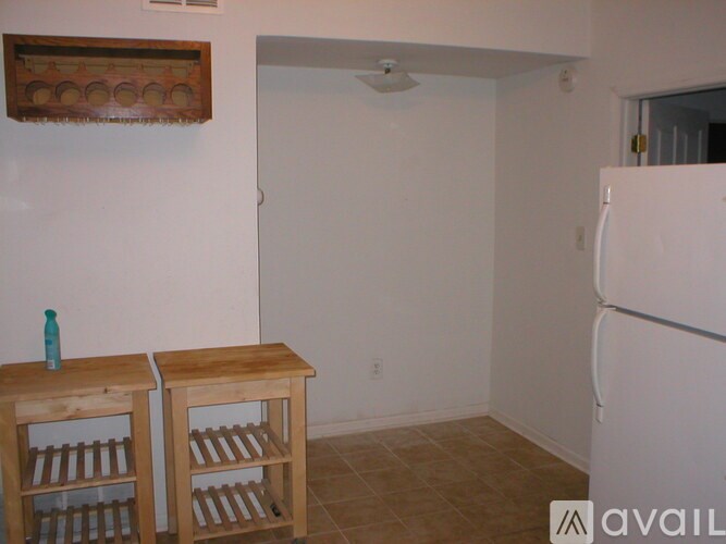 A kitchen with a white refrigerator and wooden shelves.