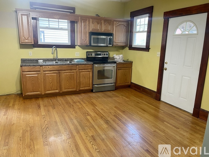 A kitchen with wooden cabinets and a white door.