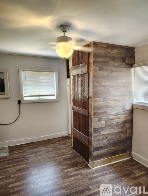 A bedroom with a bed, dresser, and a wooden wall.