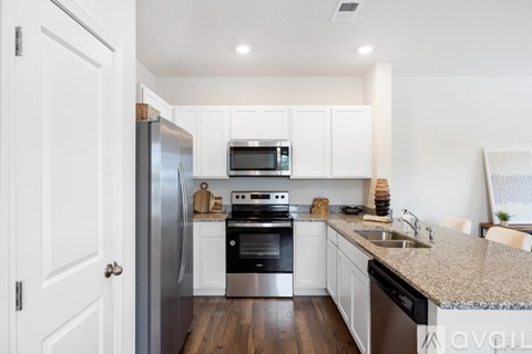 A kitchen with white cabinets and stainless steel appliances.