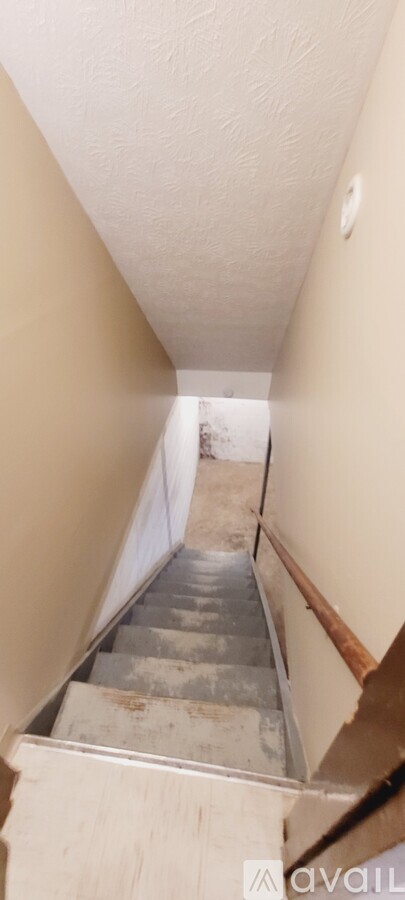 A staircase with a metal railing and wooden steps.