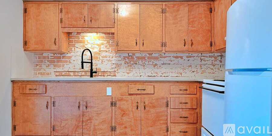 A kitchen with wooden cabinets and a brick backsplash.