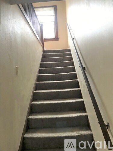 A flight of stairs with a metal railing on the right side.