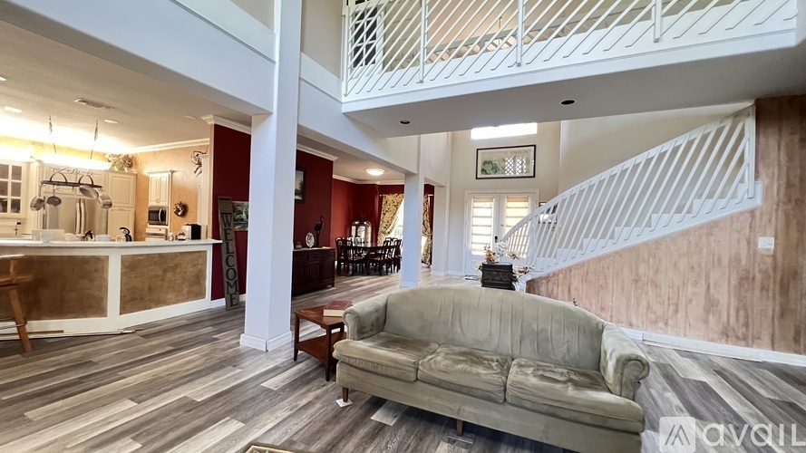A living room with a couch and a staircase.