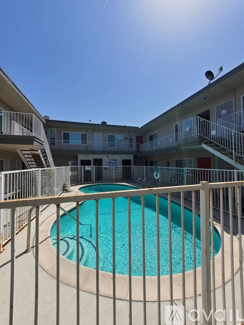 A pool surrounded by a fence in front of a building.