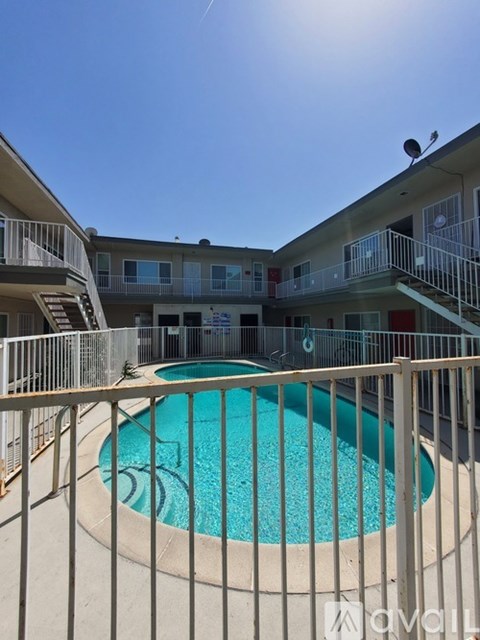 A pool surrounded by a fence in front of a building.