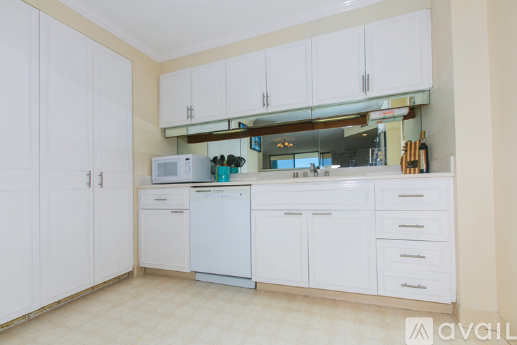 A kitchen with white cabinets and appliances.