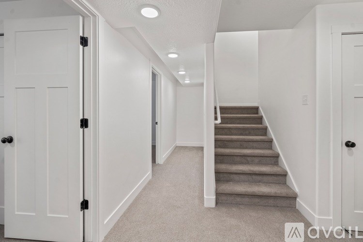 A hallway with a staircase and white doors.