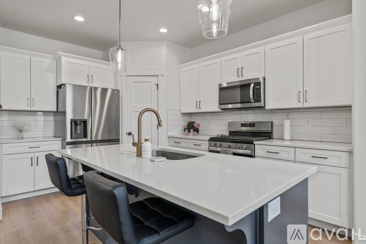 A kitchen with white cabinets and a large island.