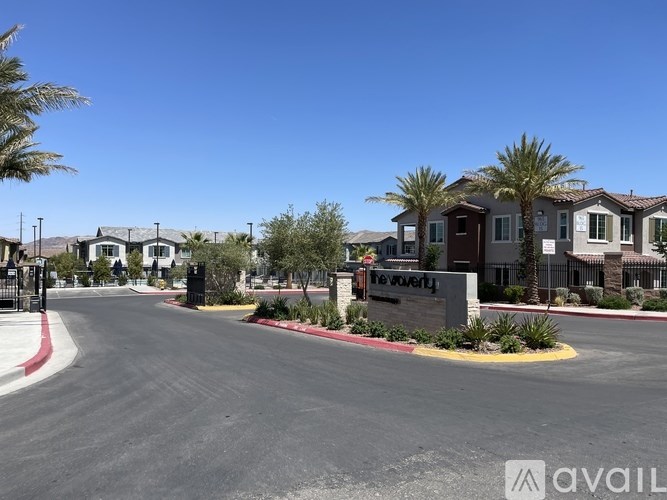 A street view of a residential area with houses and palm trees.