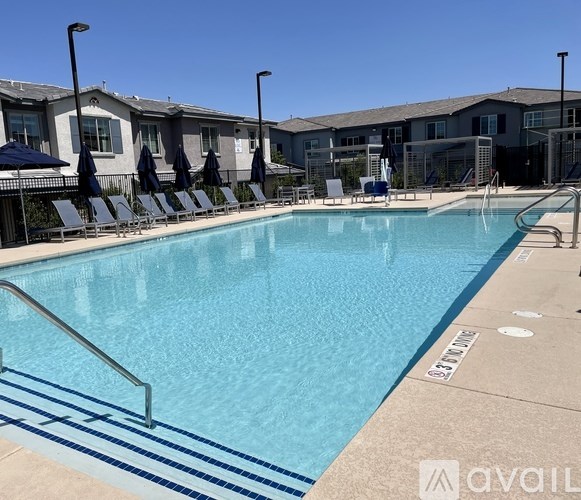 A swimming pool with a blue tiled edge and a metal ladder on the right side.