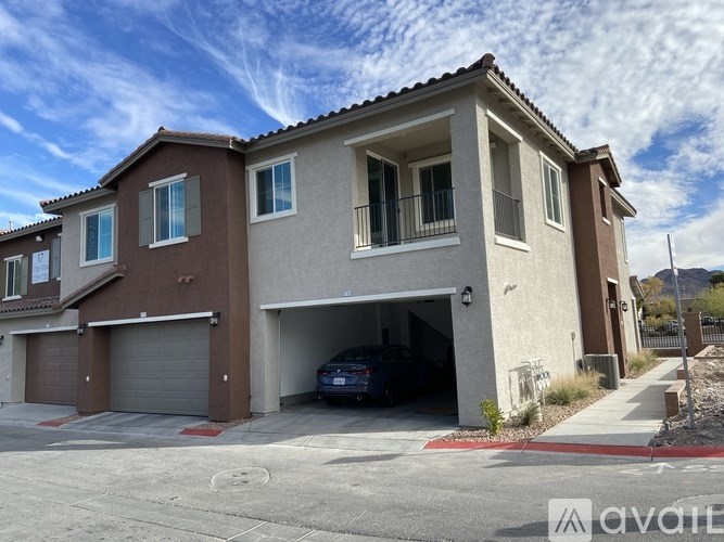 A two-story house with a garage and a car parked inside.