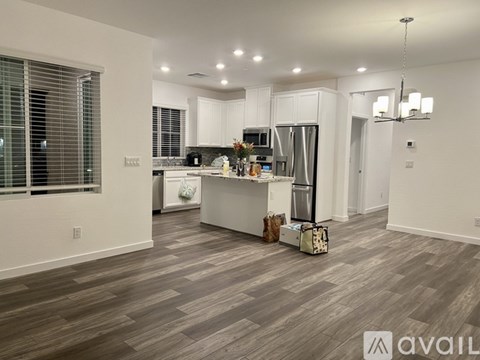 A kitchen with white cabinets and a wooden floor.