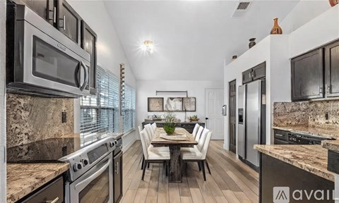 A modern kitchen with a dining table set for four.