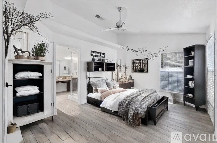A bedroom with a large bed and a wooden floor.