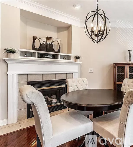 A dining room with a fireplace, a table, and chairs.