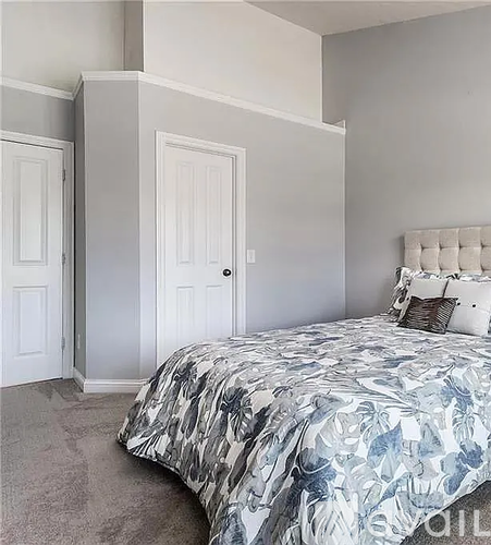 A bedroom with a bed and a white headboard.