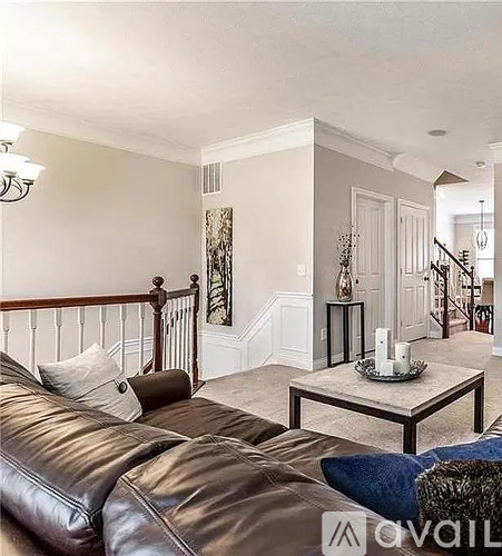 A living room with a brown leather couch and a coffee table.