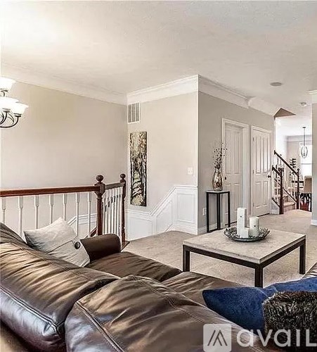 A living room with a brown leather couch and a coffee table.