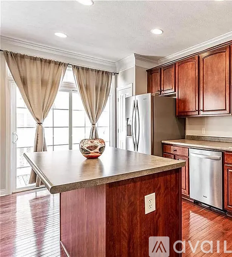 A kitchen with wooden cabinets and a marble countertop.