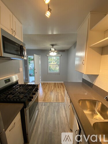 A kitchen with a stove top oven, microwave, and sink.