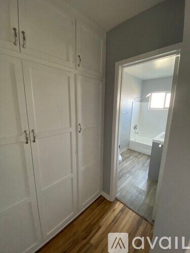 A room with white cupboards and a mirror on the wall.