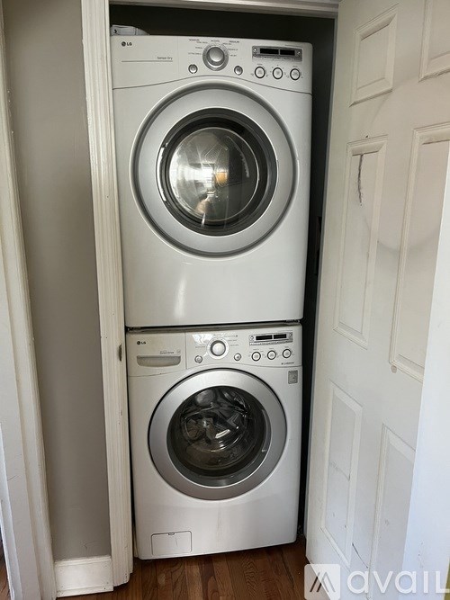 A white washing machine and dryer stacked on top of each other in a small space.
