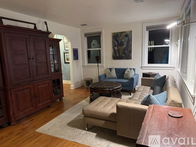 A living room with a brown cabinet and a blue chair.
