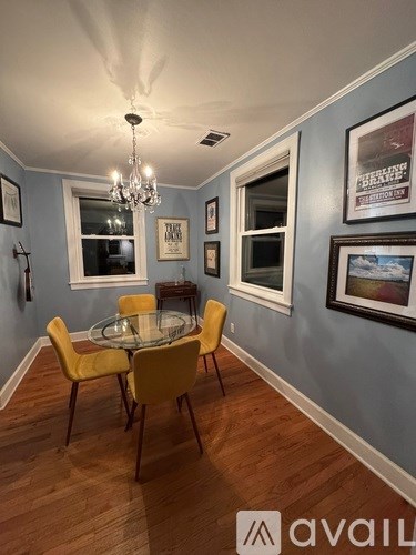 A dining room with a glass table and yellow chairs.