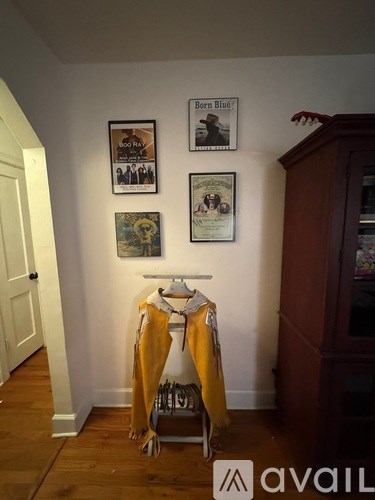 A room with a coat rack and posters on the wall.