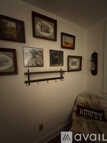 A wall with pictures and a shelf.