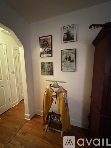 A room with a coat rack and pictures on the wall.