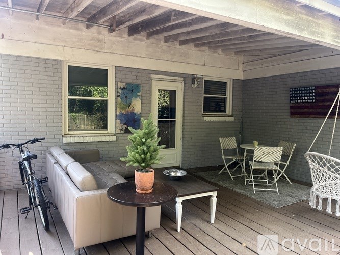 A patio with a table, chairs, and a bicycle.
