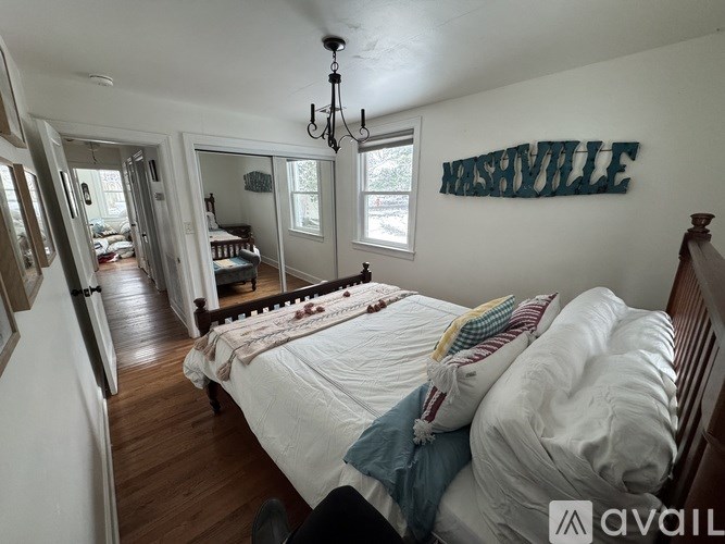 A bedroom with a bed and a chandelier.