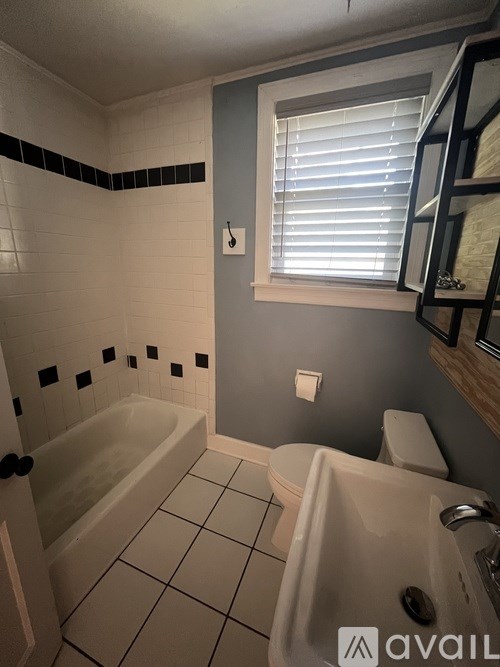 A bathroom with a bathtub, toilet, and sink.