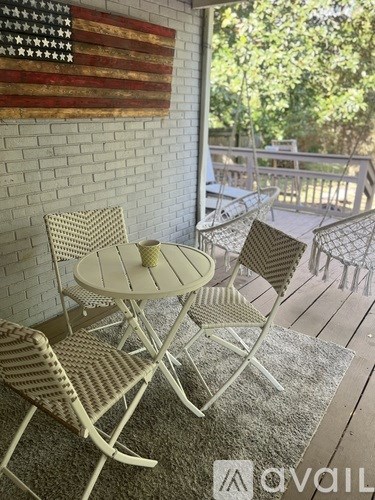 A white table and chairs are set up on a wooden deck.