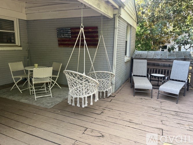 A porch with a swing hanging from a rope.