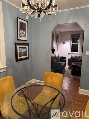 A dining room with a glass table and yellow chairs.