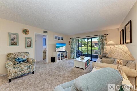 A living room with a couch, chair, and a television.