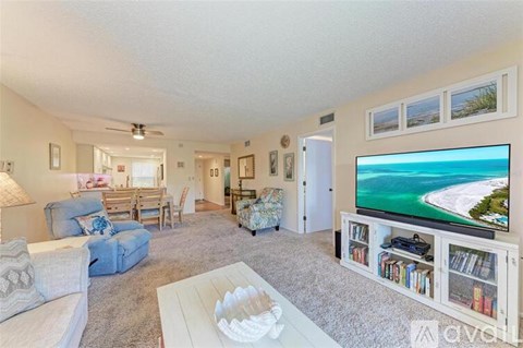 A living room with a television displaying a beach scene.