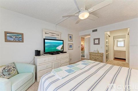 A bedroom with a bed, a couch, and a television.