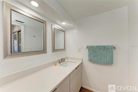 A bathroom with a white countertop and a large mirror above the sink.