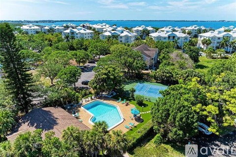 A bird's eye view of a resort with a swimming pool surrounded by trees.