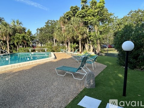 A pool area with chairs and a lamp post.
