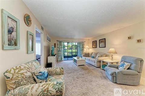 A living room with a couch, chair, and a painting of a bird on the wall.