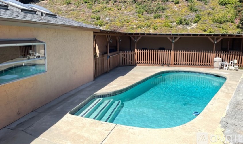A small pool in a backyard with a wooden fence.